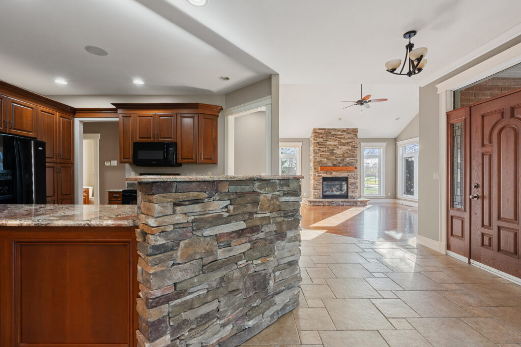Before photo of kitchen with stone half-wall and dark cabinets — Pentilly renovation